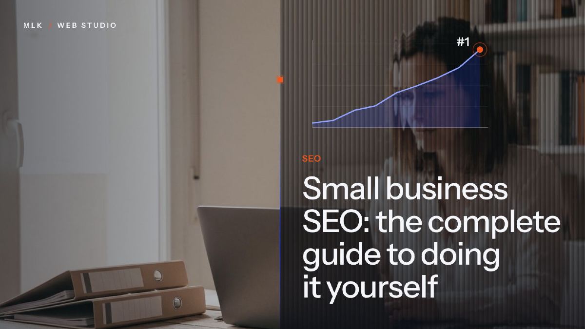 The word SEO and a rising chart that reaches number one, beside a laptop and two binders on a desk
